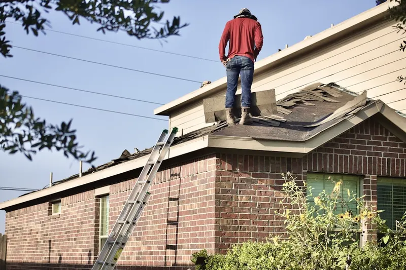 Professional roofer working on a residential roof in Delong